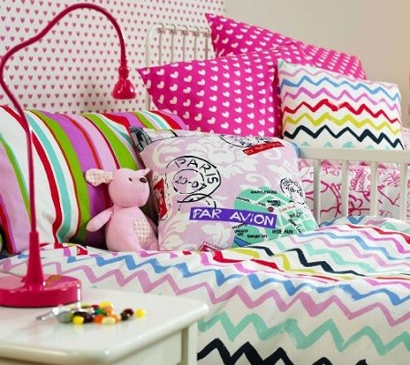 decorar una cama con cojines juveniles